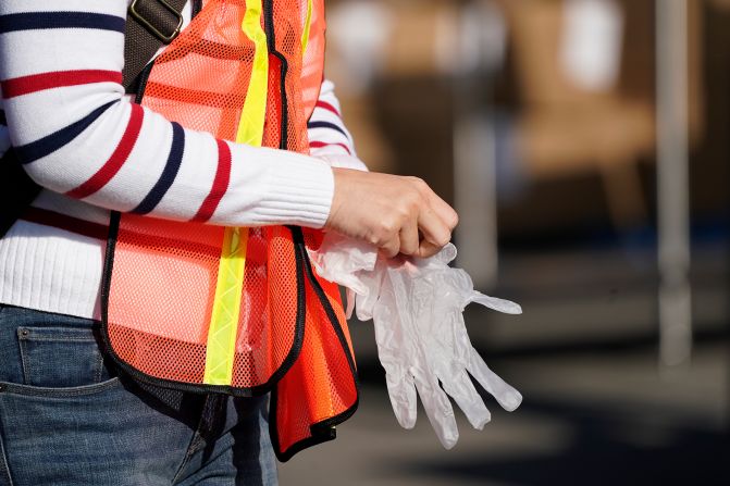 A volunteer puts on gloves before packing boxes of food outside the Second Harvest Food Bank in Irvine, California, on November 19.