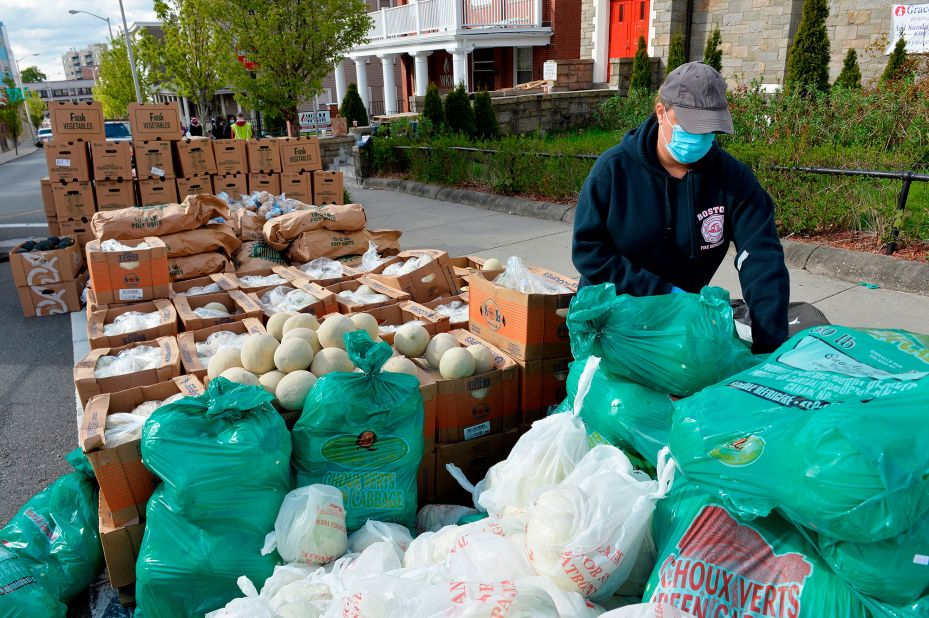 Volunteers load plastic bags with food in Everett, Massachusetts, during a weekly food pantry service run by Grace Ministries of the North Shore.