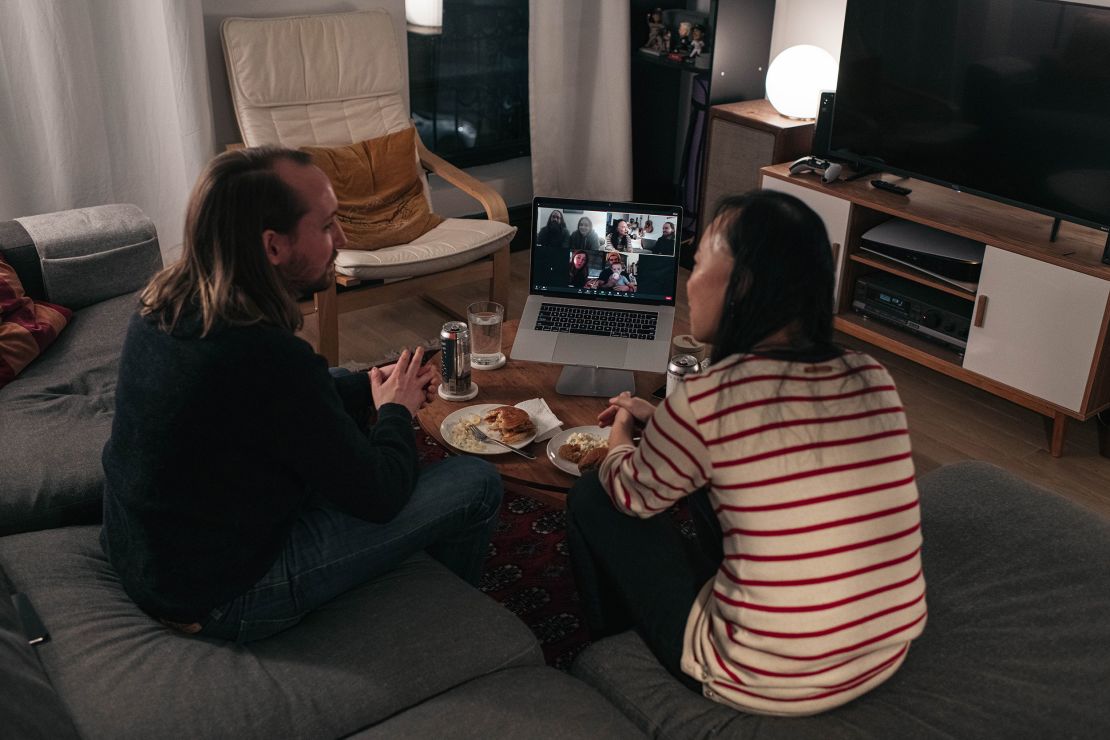 A couple celebrates Thanksgiving with friends by having dinner together over a Zoom video call on November 22, 2020, in New York.