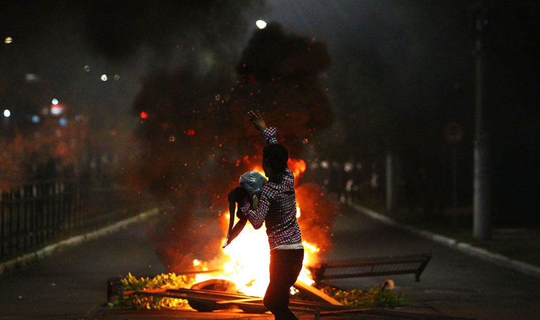 A man demonstrates in front of a bonfire during a protest against the death of Joao Alberto in Porto Alegre, Brazil on November 23, 2020. 