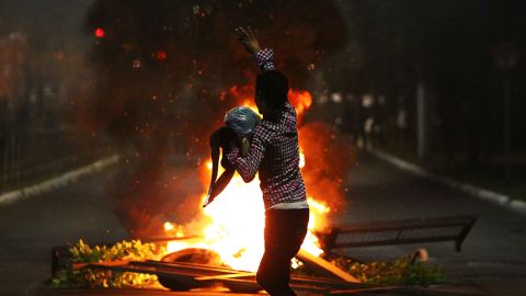 A man demonstrates in front of a bonfire during a protest against the death of Joao Alberto in Porto Alegre, Brazil on November 23, 2020. 