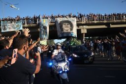 Mourning fans wave from an overpass at the caravan carrying the remains of Diego Maradona to his resting place in Buenos Aires on Thursday.