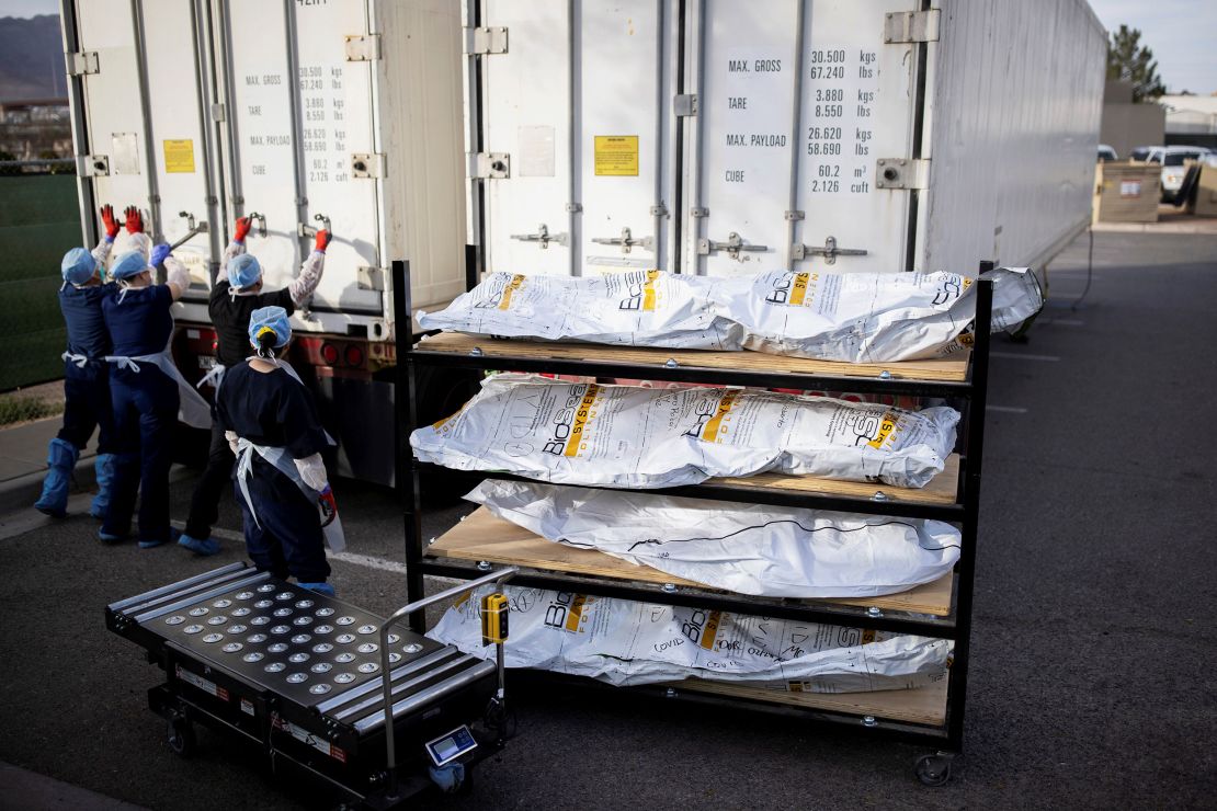 El Paso County Medical Examiner's Office staff lock up mobile morgues before moving bodies in bags labeled "Covid."