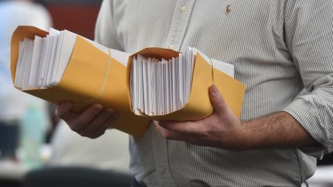An employee holds bundles of mail-in ballots to be counted after the election in Wilkes-Barre, Pennsylvania, on November 4, 2020.