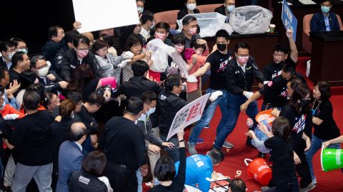 Kuomintang (KMT) lawmakers throw pig offal on the podium in Taiwan's parliament in Taipei, on November 27, 2020. 