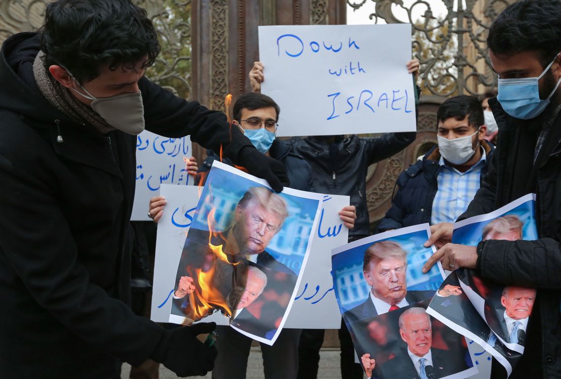 Students of Iran's Basij paramilitary force burn posters depicting Donald Trump and Joe Biden during at the foreign ministry in Tehran, on November 28, 2020, to protest the killing of prominent nuclear scientist Mohsen Fakhrizadeh a day earlier near the capital.