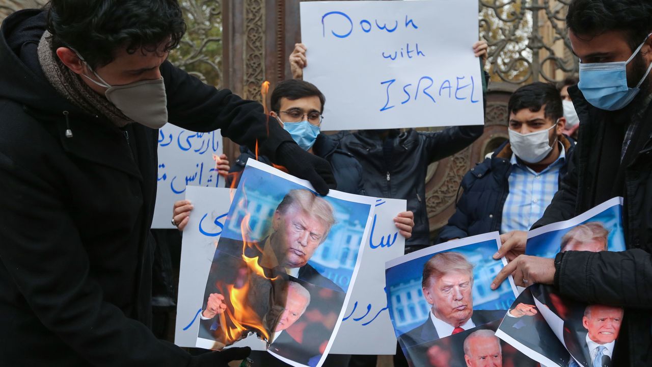 Students of Iran's Basij paramilitary force burn posters depicting Donald Trump and Joe Biden during at the foreign ministry in Tehran, on November 28, 2020, to protest the killing of prominent nuclear scientist Mohsen Fakhrizadeh a day earlier near the capital.