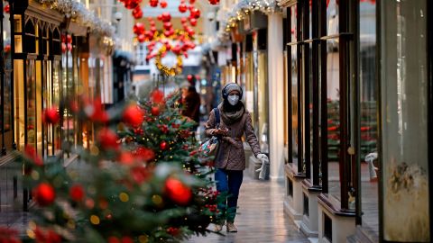 A mask-wearing pedestrian walks past Christmas-themed displays in London on November 27, as life under a second coronavirus lockdown continues in England.