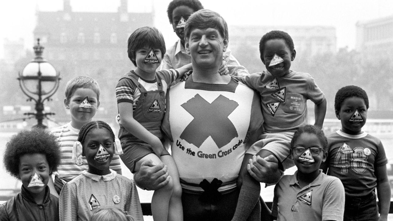 Dave Prowse in his role as the Green Cross Code Man, with students from Lambeth Johanna Primary School in London.