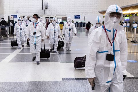 Airline crew members wearing protective suits arrive at Los Angeles International Airport on November 24.