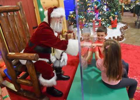 Cali Hammer fist-bumps Santa, who was behind a plexiglass partition at a Cabela's store in Tilden Township, Pennsylvania, on November 20.