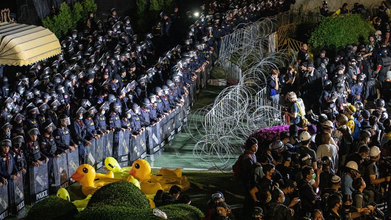 Riot police stand guard behind barbed wires and inflatable yellow ducks during an anti-government demonstration in the Thai capital.