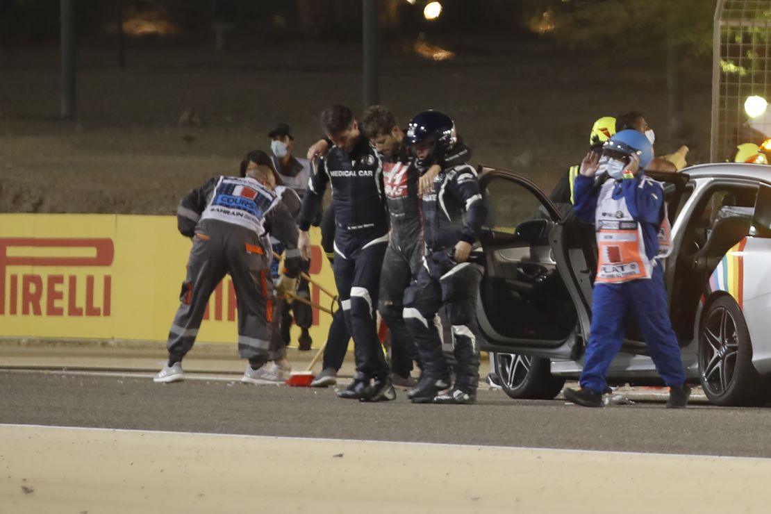 Stewards and medics attend to Romain Grosjean after the crash.