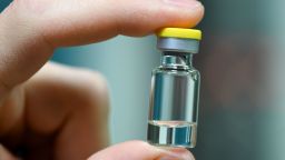 An employee of the vaccine production company IDT Biologika shows an Ampoule during the visit by German health minister Spahn in Dessau, eastern Germany on November 23, 2020 as the race to develop a Covid-19 vaccine continues. (Photo by Hendrik Schmidt / POOL / AFP) (Photo by HENDRIK SCHMIDT/POOL/AFP via Getty Images)