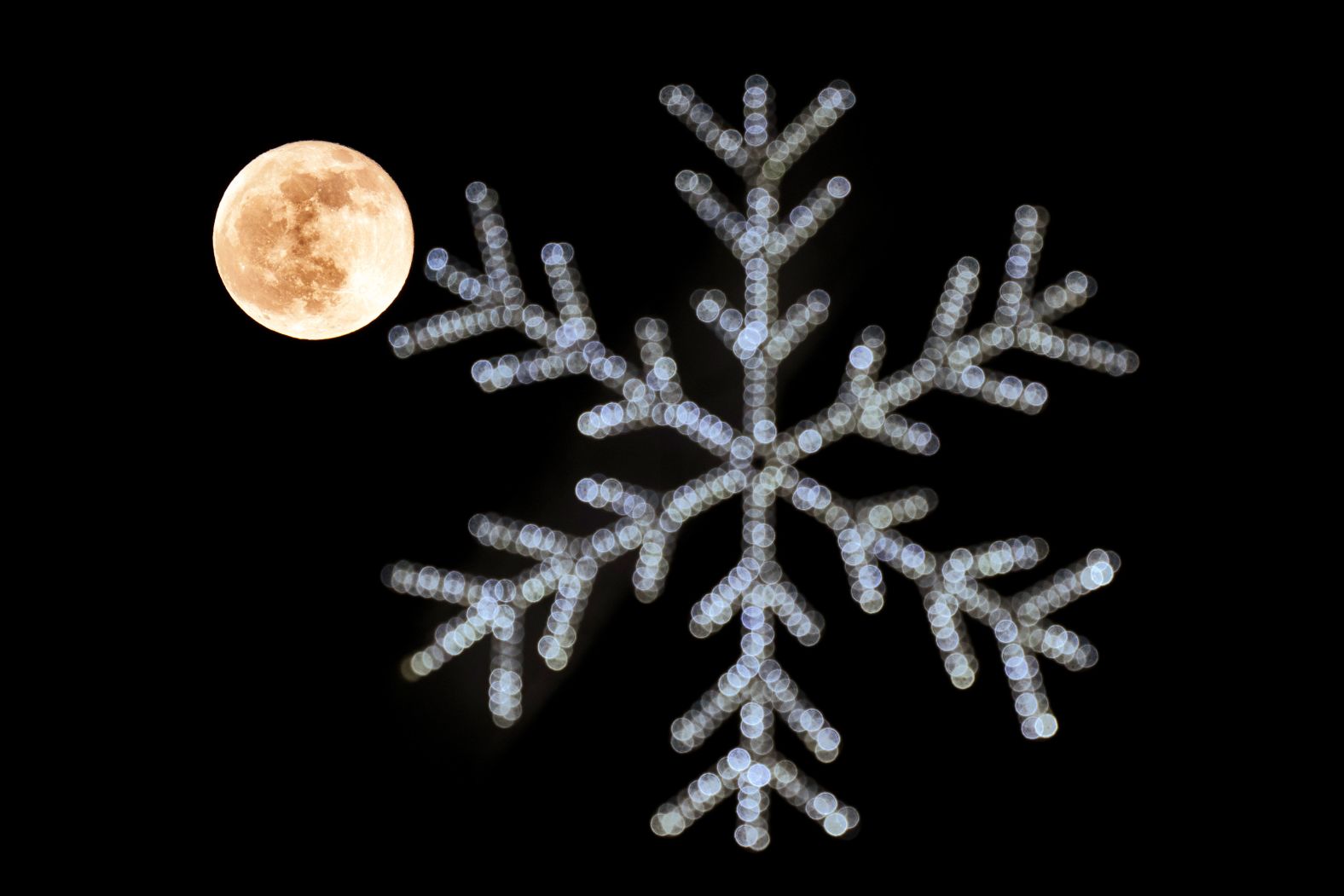 A full moon rises behind holiday lights in Whittier, California.