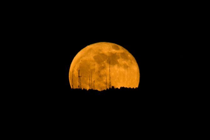 The luminous full moon rises behind a mountain in Los Angeles, November 30.