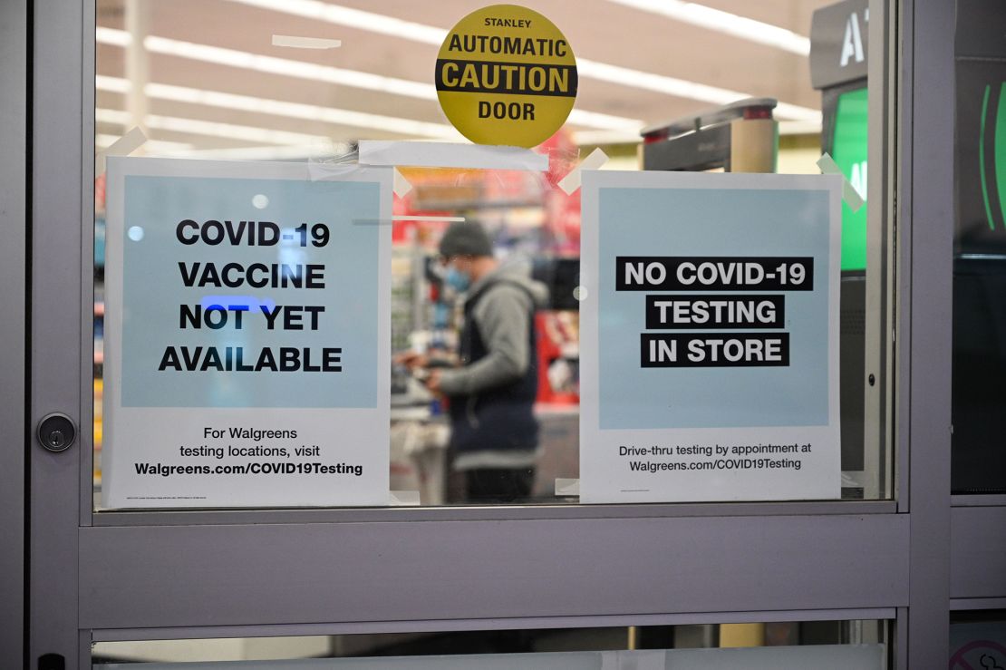 A sign on the entrance to a pharmacy reads "Covid-19 Vaccine Not Yet Available."