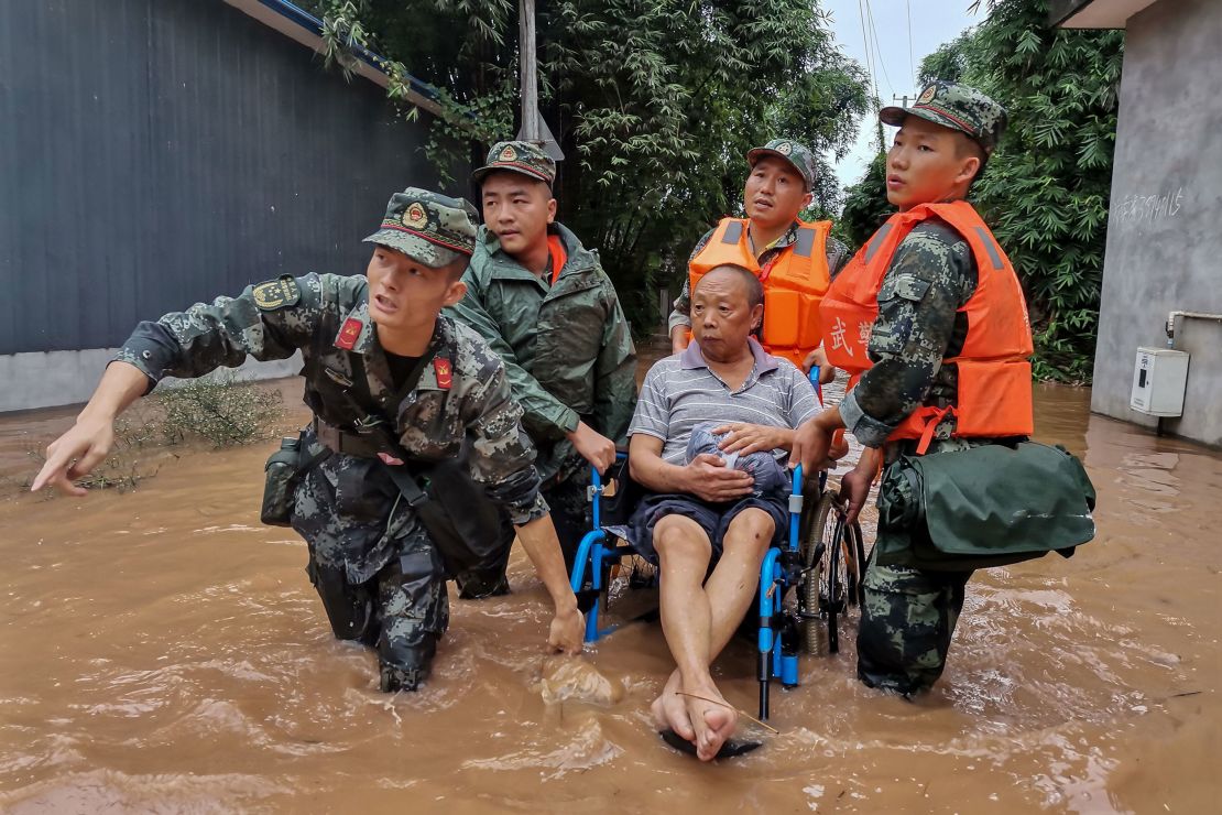 A resident is evacuated from a flooded street in Meishan in China's southwestern Sichuan province.