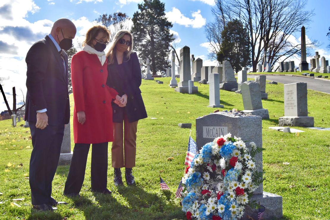 Mark Kelly, who will be sworn in as a US senator on Wednesday, and his wife, former Rep. Gabby Giffords, visit the gravesite of the late Sen. John McCain in Annapolis, Maryland, on Tuesday. 