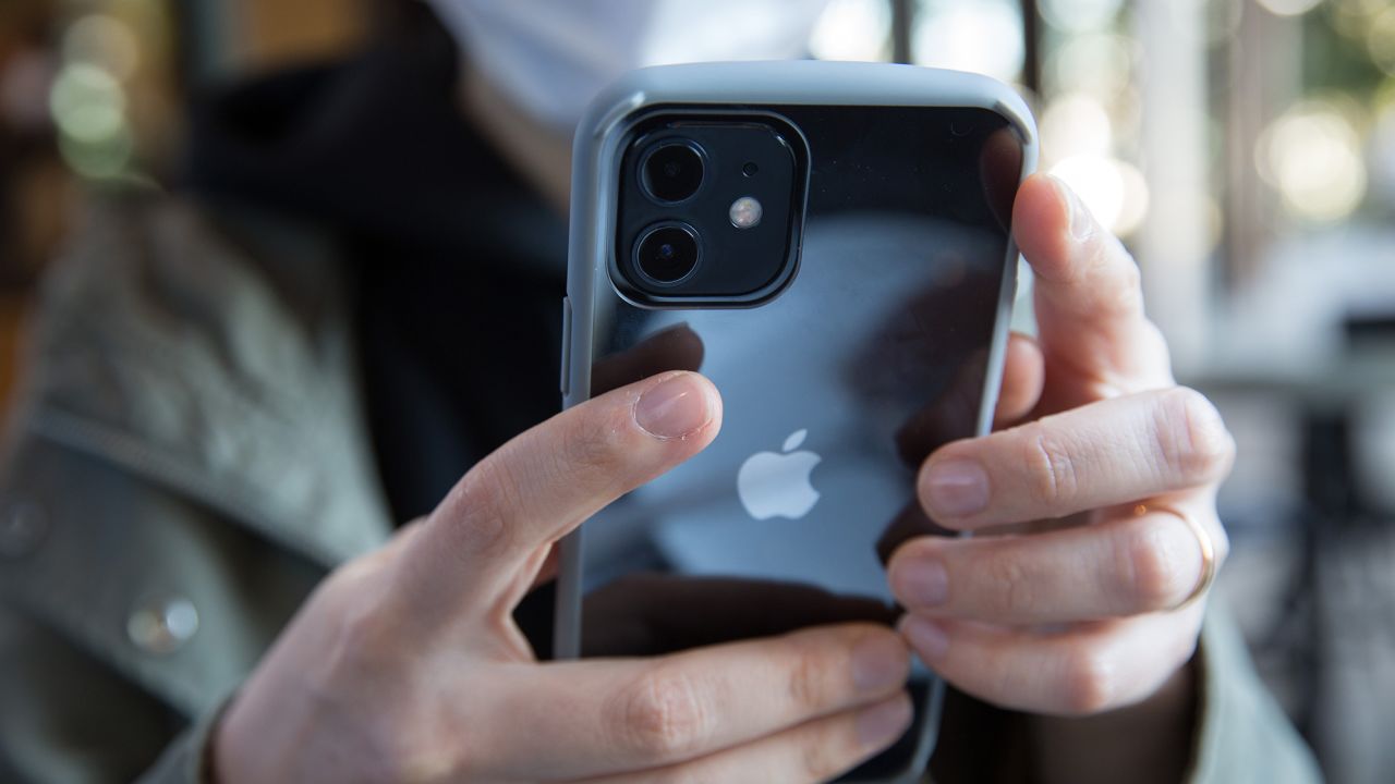 A woman holds the new iPhone 12 in her hands.
