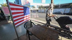 Empty patio tables separated by plastic dividers adorned with American flags are seen at Mel's drive-in diner in West Hollywood, California on November 30, 2020, after Los Angeles County banned outdoor dining in an attempt to stem the latest surge in coronavirus cases. - Many restaurant owners, who have already spent thousands of dollars to ensure a safe and compliant outdoor dining experience, say the latest shut down of outdoor dining with be financially devastating. (Photo by Robyn Beck/AFP/Getty Images)