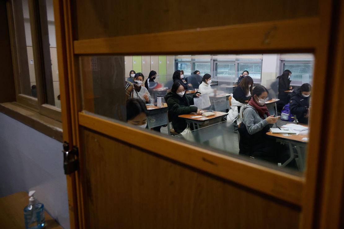Students wearing face masks wait for the start of the annual college entrance examination amid the coronavirus pandemic at an exam hall in Seoul, South Korea, on December 3, 2020. 