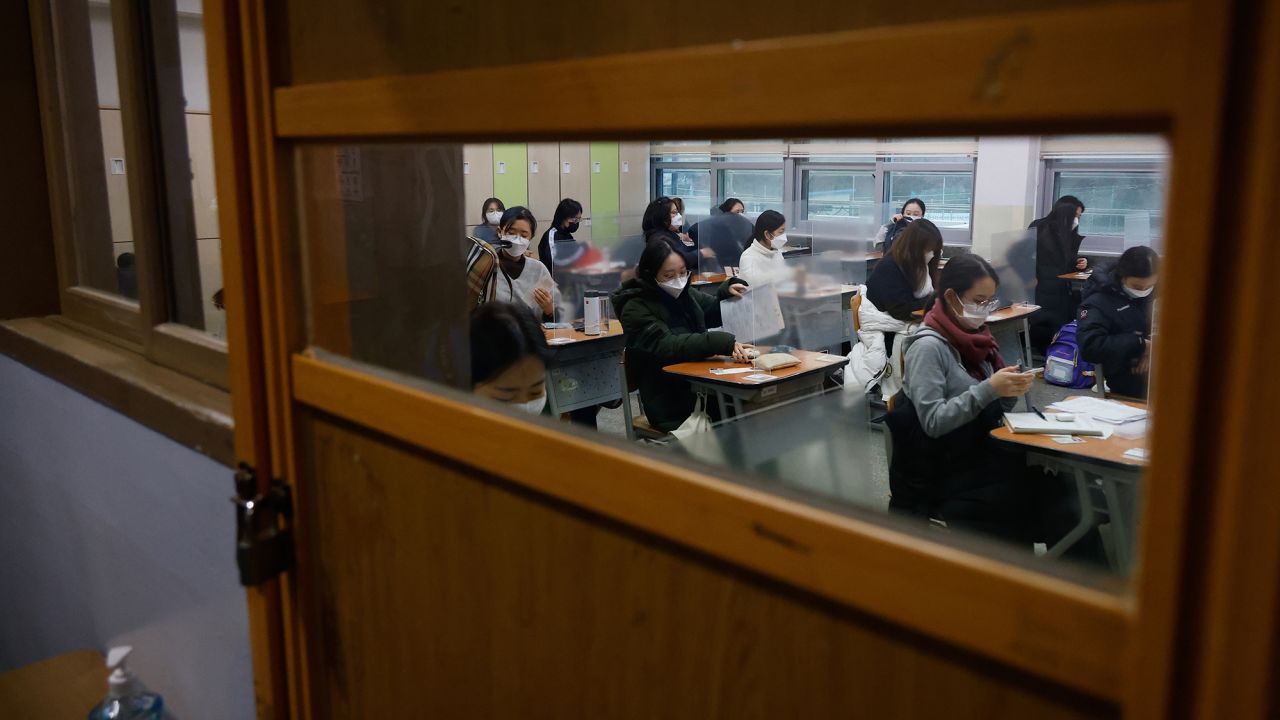 Students wearing face masks wait for the start of the annual college entrance examination amid the coronavirus pandemic at an exam hall in Seoul, South Korea, on December 3, 2020.