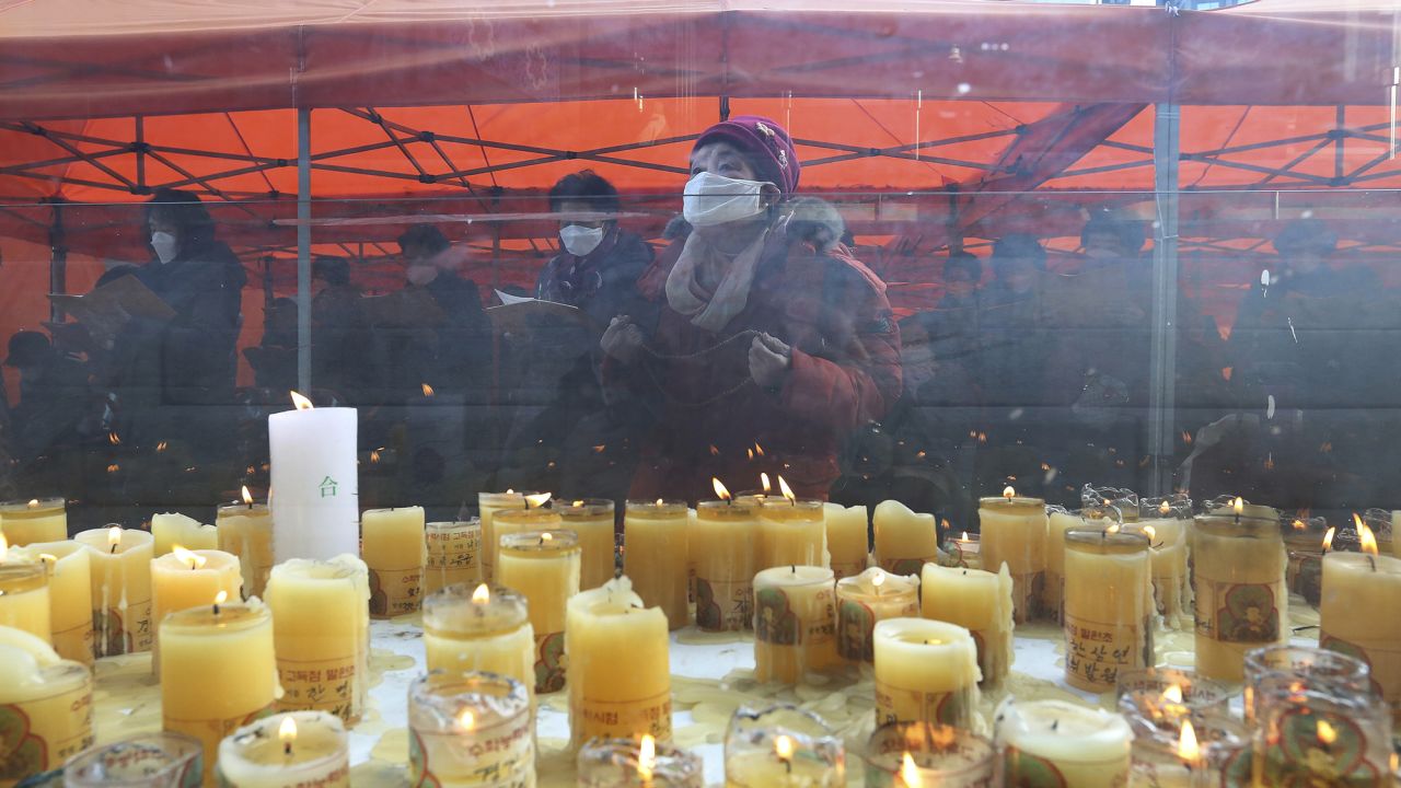 Parents wearing face masks pray during a service to wish for their children's success on the eve of the college entrance exam at the Jogyesa Buddhist temple in Seoul, South Korea, on December 2, 2020.