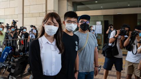 Pro-democracy activists Agnes Chow, Joshua Wong and Ivan Lam speak to media outside court on August 5, 2020, in Hong Kong. All three were jailed on December 2. 