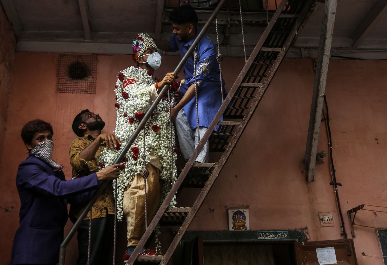 A groom wears protective face masks as he arrives with relatives for his wedding in Mumbai, India.