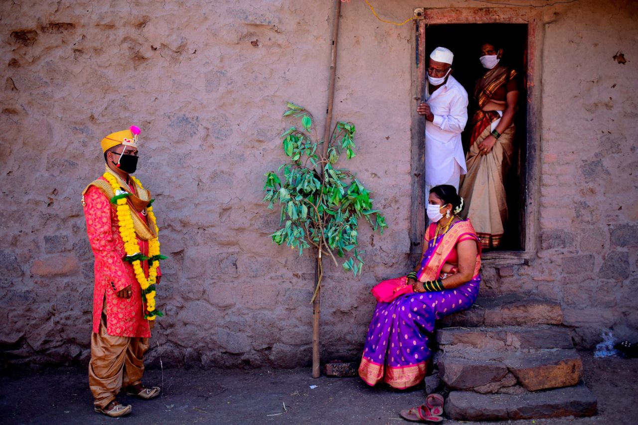 A groom speaks with his bride and family members following their wedding during a government-imposed nationwide lockdown in Pune.