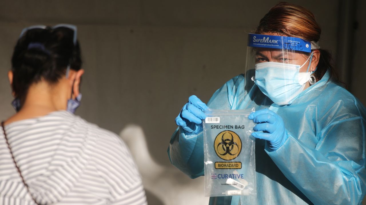 SAN FERNANDO, CALIFORNIA - DECEMBER 2: A healthcare worker holds a specimen bag at a walk-up Covid-19 testing site on December 2, 2020 in San Fernando, California. California reported 20,759 new coronavirus cases today, a one-day record for the state, amid a new limited stay-at-home order in Los Angeles County. (Photo by Mario Tama/Getty Images)