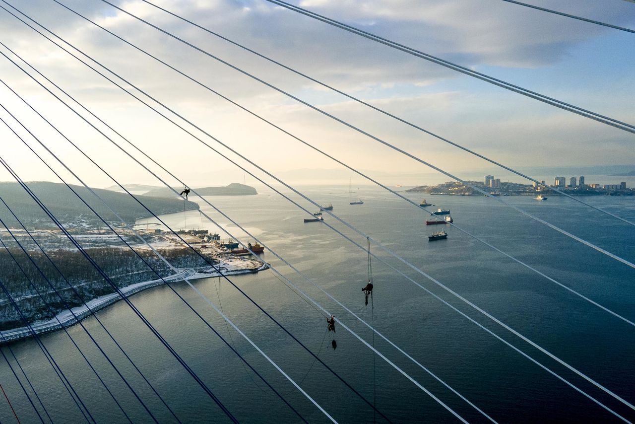Industrial climbers remove ice from the cables of the Russky Bridge, across the Eastern Bosphorus strait in Vladivostok, Russia, on Monday, November 30.
