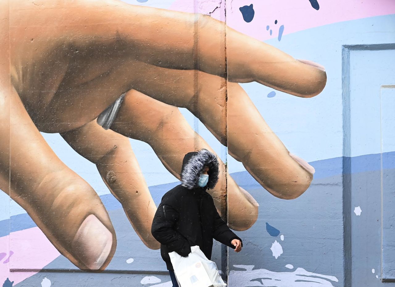 A man walks past a mural in Toronto on Tuesday, December 1. The city has been on lockdown since last month.