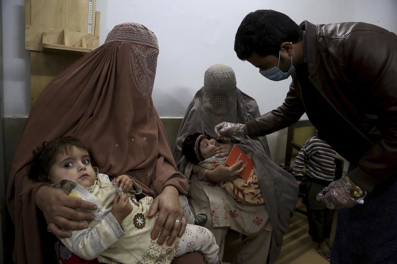 A health-care worker administers a polio vaccine to a child at a clinic in Peshawar, Pakistan, on Tuesday, December 1.