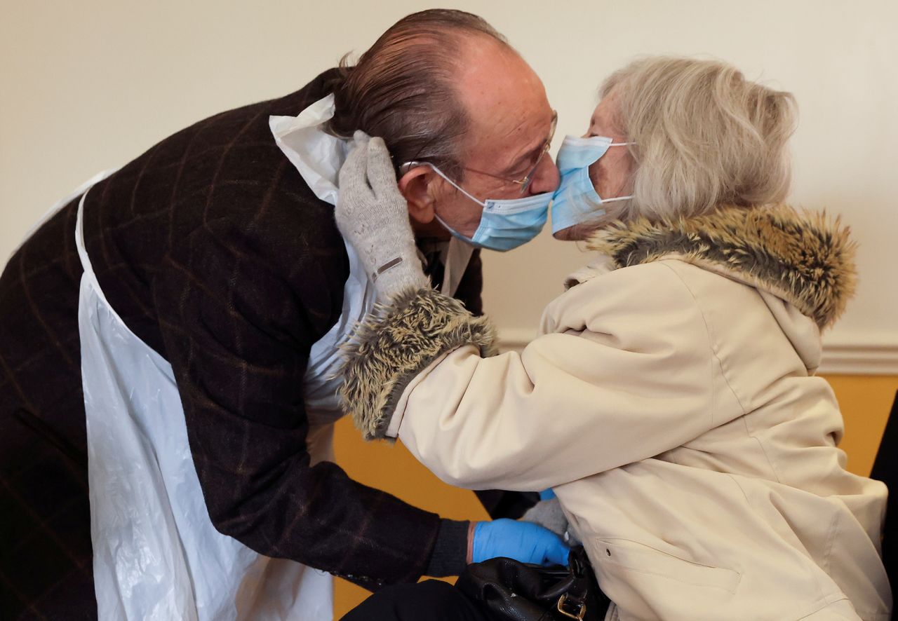 Bob Underhill and his wife, Patricia, kiss through face masks at the Chiswick Nursing Centre in London on Wednesday, December 2. Visits with physical contact were being allowed for the first time after the facility introduced a Covid-19 test with results ready in 30 minutes.
