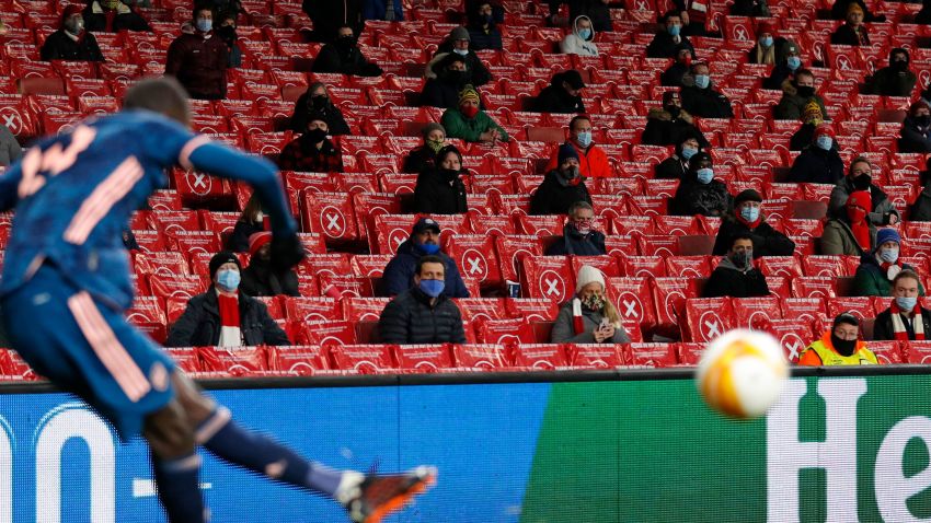 Supporters wearing protective face coverings to combat the spread of the coronavirus, watch as a corner kick is taken during the UEFA Europa League 1st Round Group B football match between Arsenal and Rapid Vienna at the Emirates Stadium in London on December 3, 2020. - Areas of England in tier two zones are now allowed up to 2,000 fans with Arsenal welcoming back supporters for the first time tonight since a four-week lockdown was lifted. (Photo by Adrian DENNIS / AFP) (Photo by ADRIAN DENNIS/AFP via Getty Images)