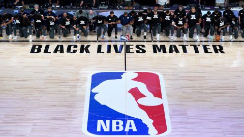 Members of the New Orleans Pelicans and Utah Jazz kneel before a Black Lives Matter logo before the start of their game at HP Field House at ESPN Wide World Of Sports Complex on July 30, 2020 in Reunion, Florida.