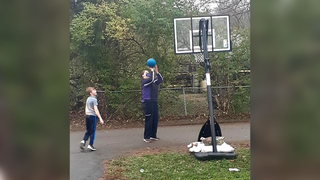 Robinson and Elijah playing basketball with his new hoop.