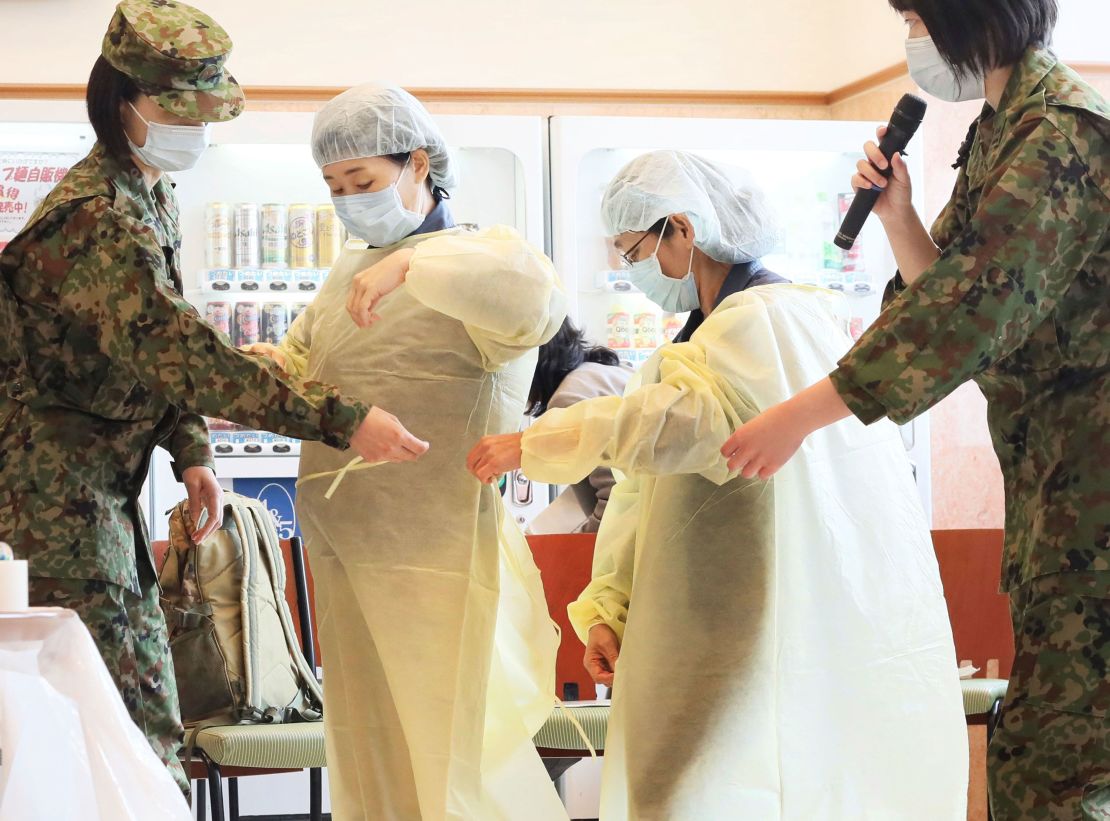 Officials are trained in putting on and taking off protective clothing by Self Defense Force (SDF) members in Japan's Kitakyushu City, Fukuoka Prefecture on April 10, 2020.