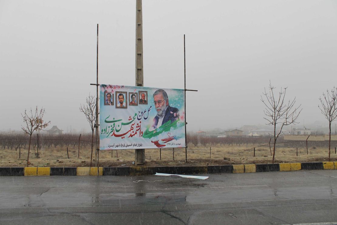 A poster of Mohsen Fakhrizadeh  stands above the spot where he was gunned down outside Tehran. 