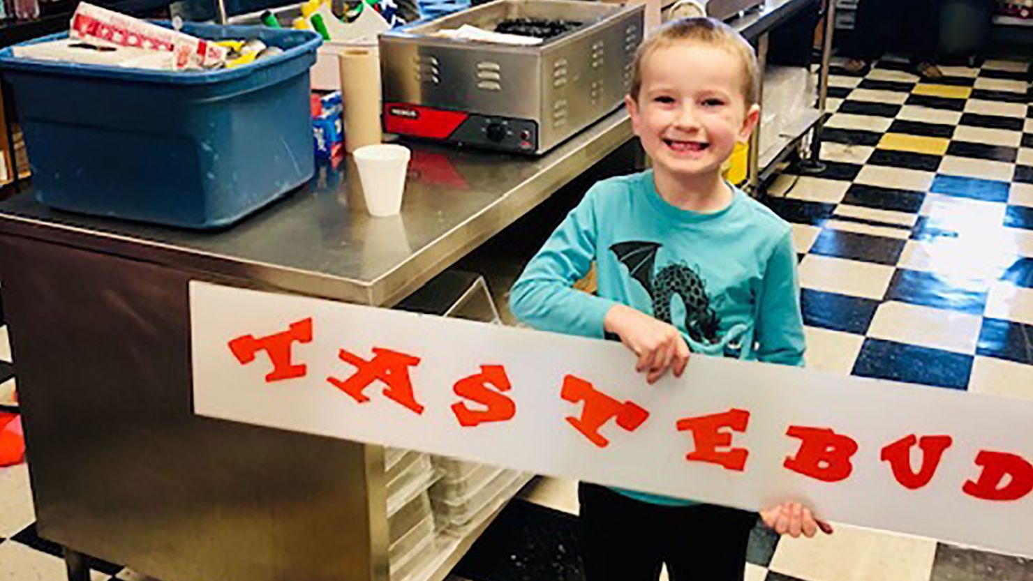 Bridget McGinty's son, Ari, holding a sign on the day the movers and volunteers came to pack up the restaurant. 