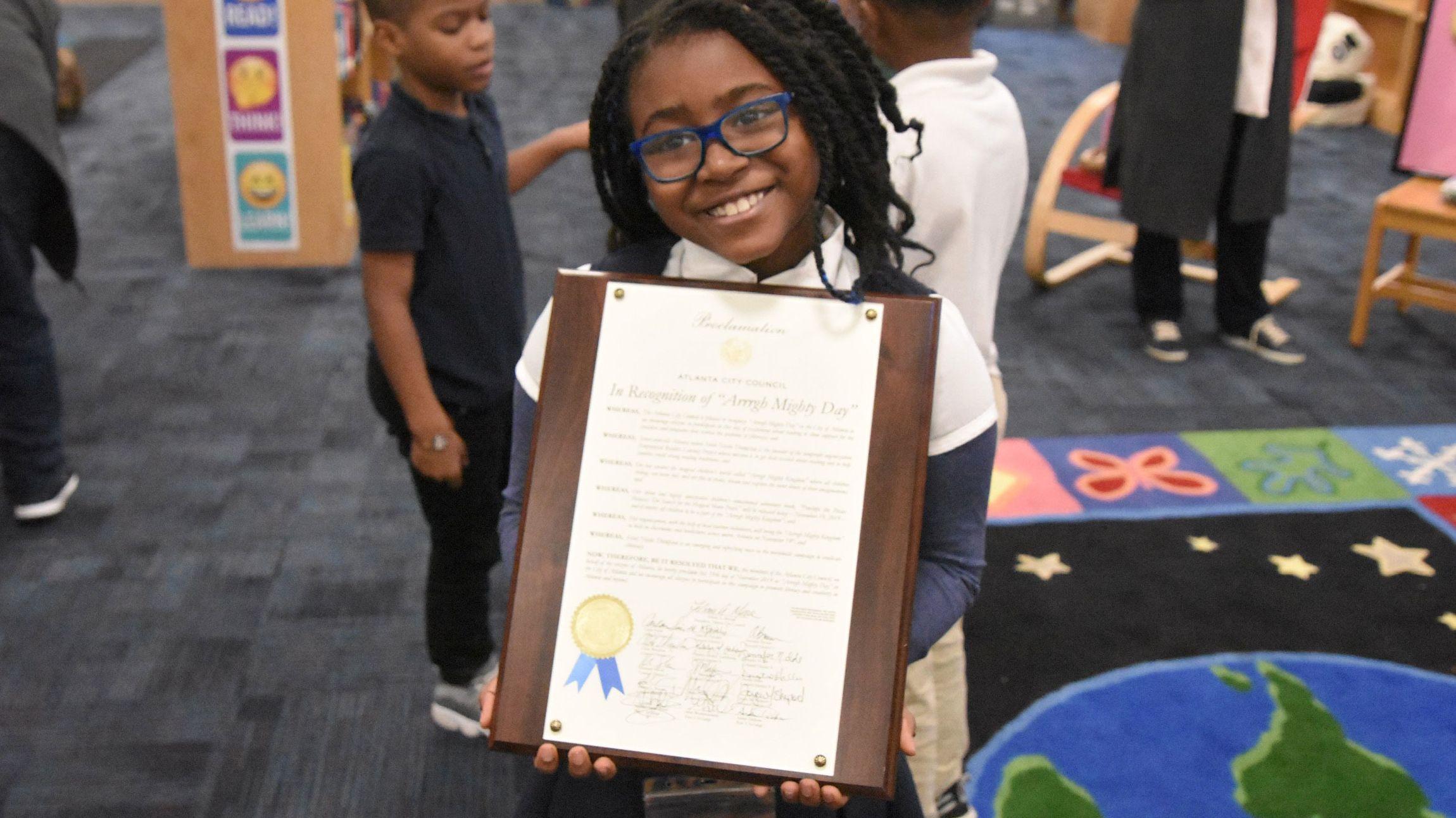 Selah Thompson with a proclamation given to her by the Atlanta City Council for her efforts to promote literacy.