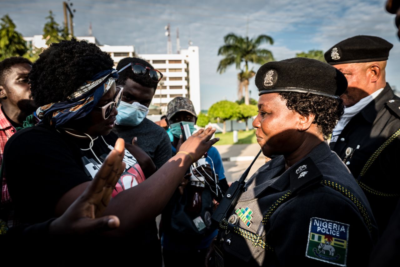 A protester addresses a police officer in front of the Nigerian Police Force headquarters during the #EndSARs protest in Abuja