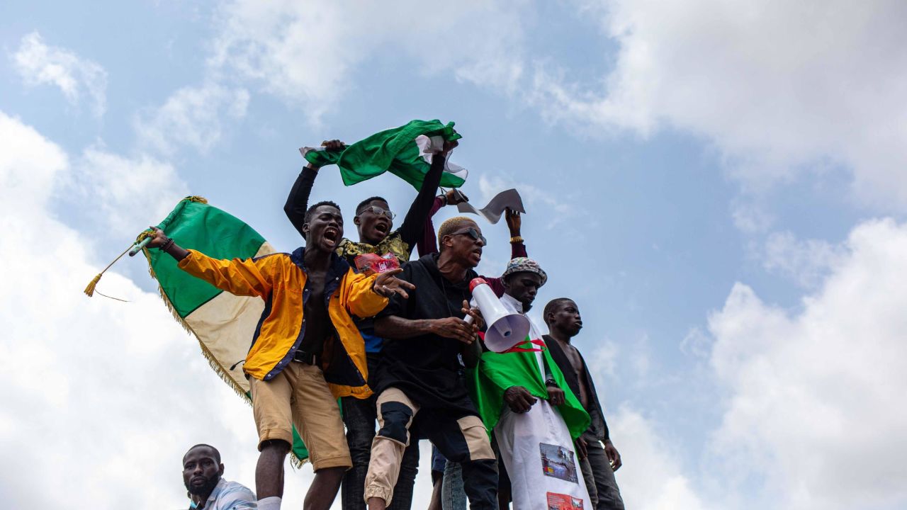 Nigerian youths seen waving the Nigerian national flag in front of a crowd in support of the ongoing protest against the unjust brutality of The Nigerian Police Force Unit named Special Anti-Robbery Squad (SARS) in Lagos on October 13, 2020