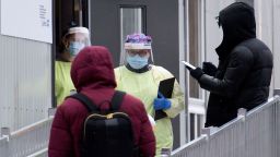 Health-care workers talk to people as they wait to be tested for COVID-19 at a testing clinic in Montreal, Sunday, Dec. 6, 2020, as the COVID-19 pandemic continues in Canada and around the world. (Graham Hughes/The Canadian Press via AP)