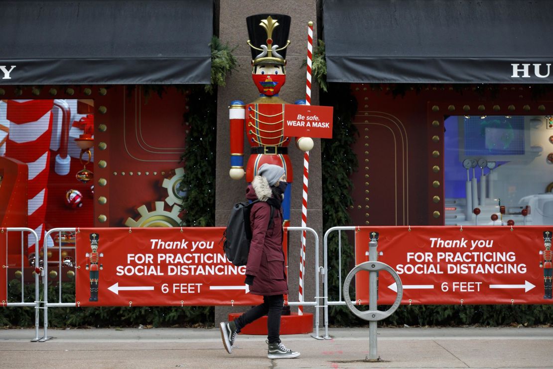 A pedestrian wearing a mask walks past a holiday display in downtown Toronto on Monday, November 23. Canada's largest province is under a lockdown to slow a second wave of coronavirus cases.