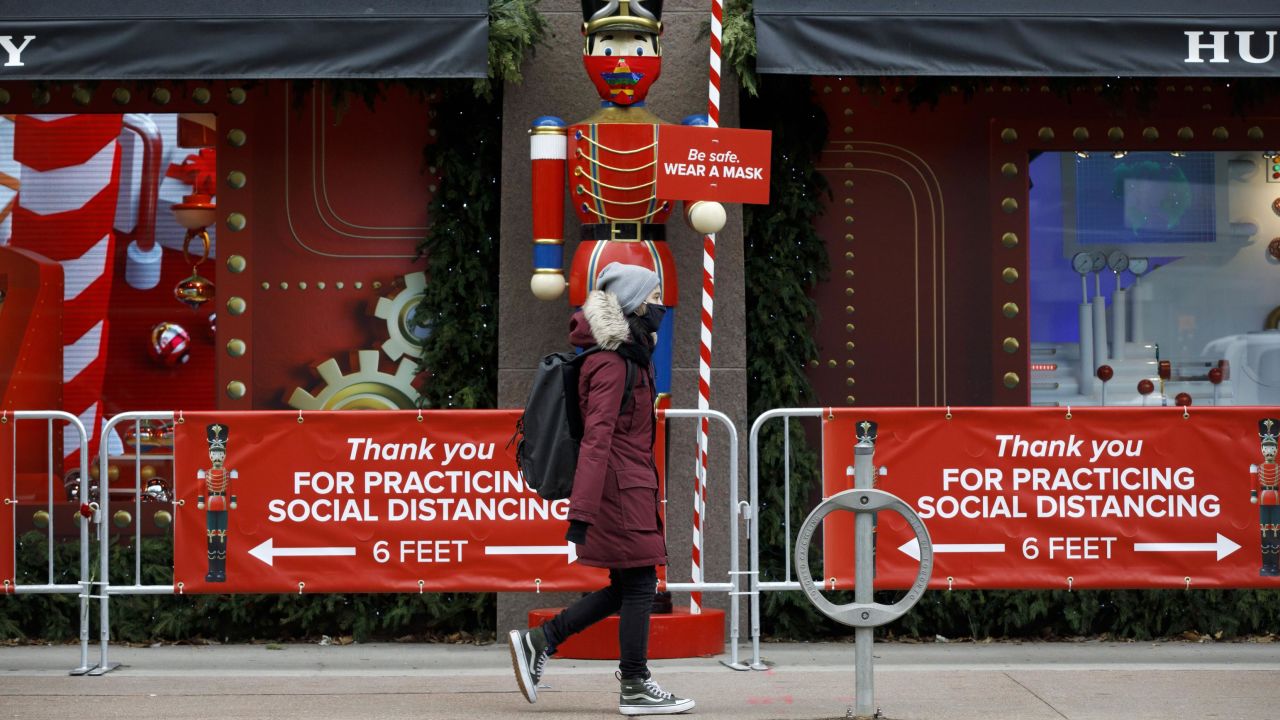 A pedestrian wearing a mask walks past a holiday display in downtown Toronto on Monday, November 23. Canada's largest province is under a lockdown to slow a second wave of coronavirus cases.