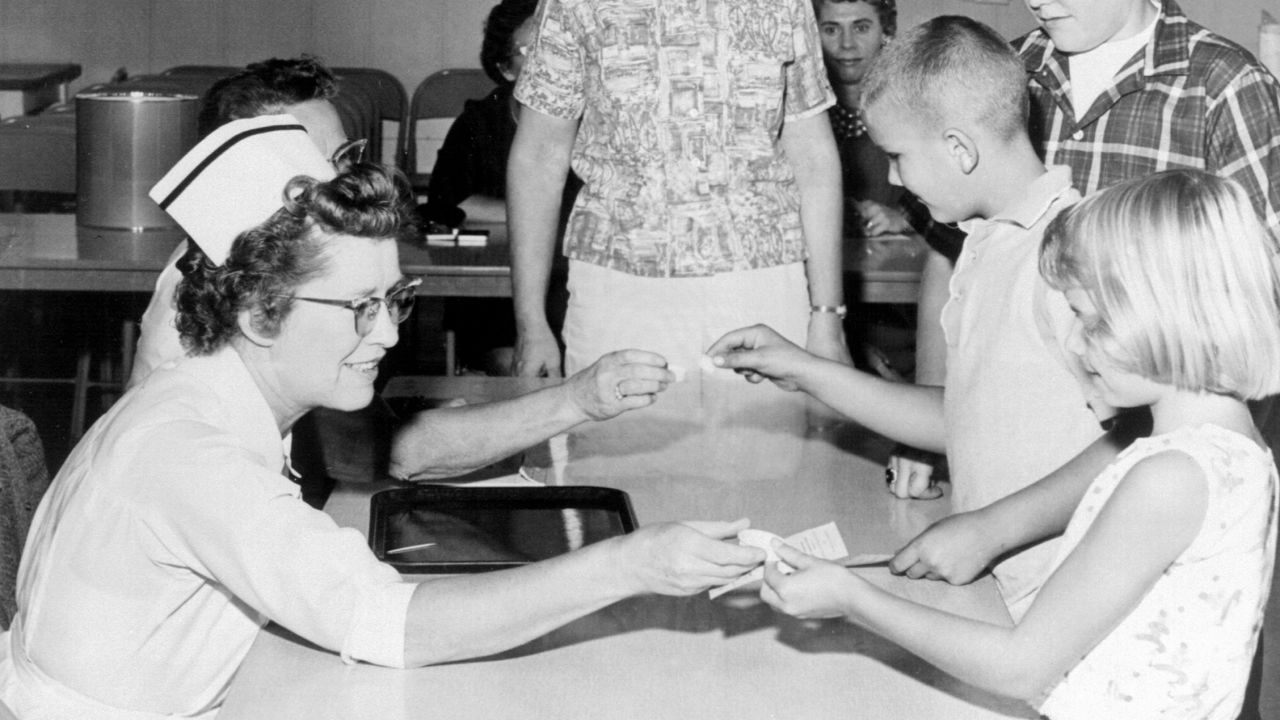 Children receive the polio vaccine on a sugar cube in the early 1960s.