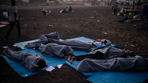 People sleep outside at the camp.